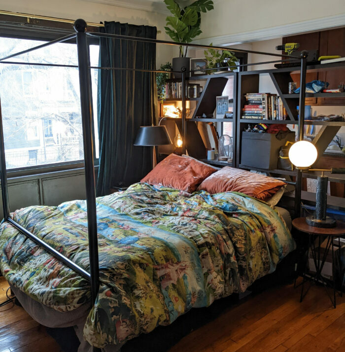 Bed with colorful linens near the shelves