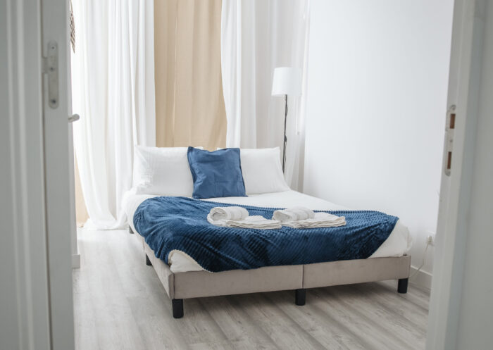 Bed near the lamp with blue and white linen&nbsp;