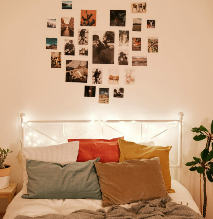 Bed with pillows near the wall with a heart shaped photo collage&nbsp;