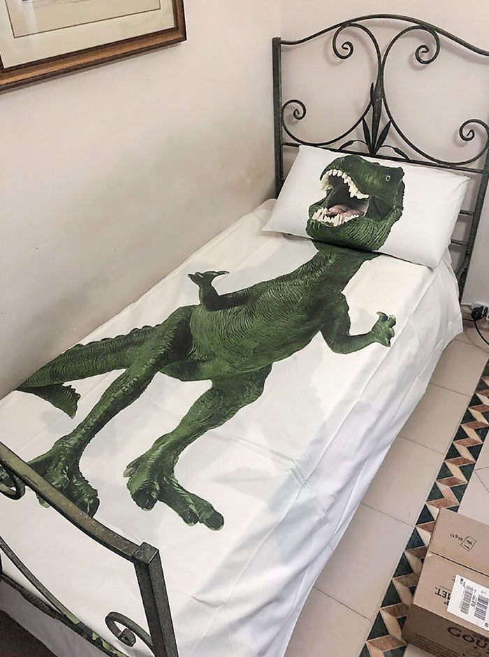 Bed with dinosaur bedding showcasing parents' humor.