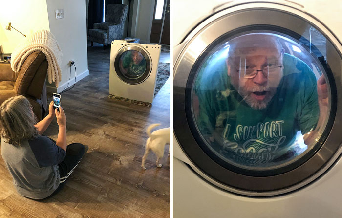 A parent with a sense of humor poses inside a dryer, as another person snaps a photo, with a curious dog nearby.
