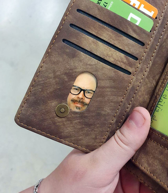 A wallet with a humorous picture of a man's face peeking through a window, showcasing parents' sense of humor.
