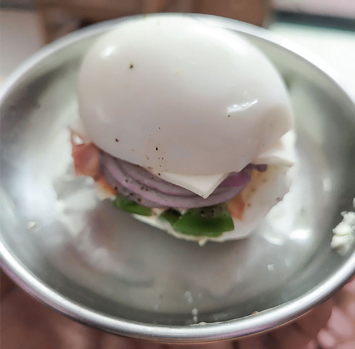 Boiled egg sandwich in a bowl showcases parents' humor with creative cooking.