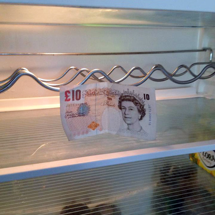 Humorous parents place a £10 note in an empty fridge, showcasing their witty sense of humor.