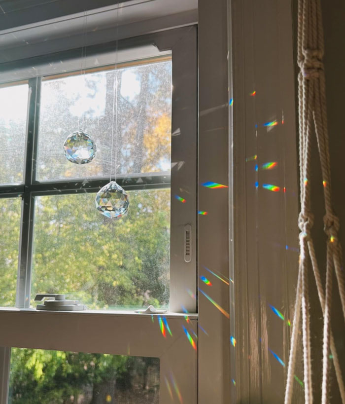 Crystal prism hanging in window casting rainbow light patterns, ideal unique gifts for the partner who’s seen it all.