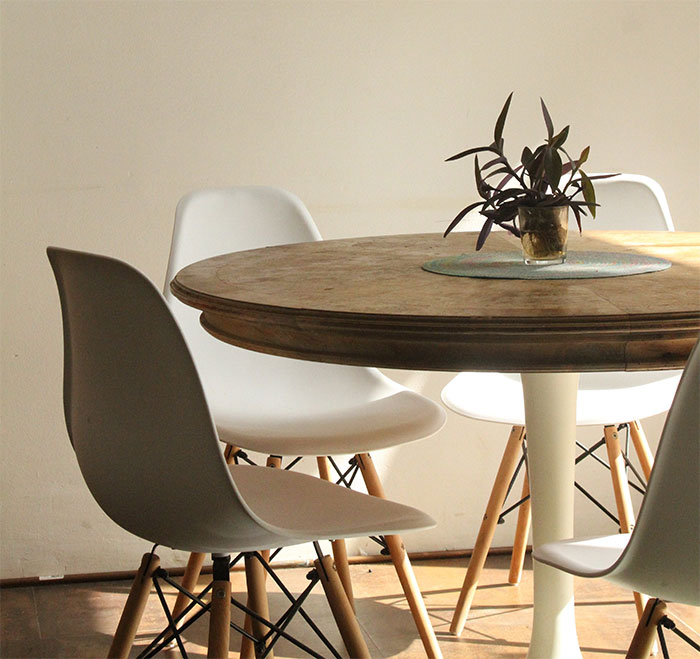 Room with empty white chairs beside table