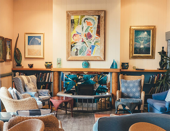 Cozy yellow room with colorful furniture and paintings showcasing the happy color that can transform your home.