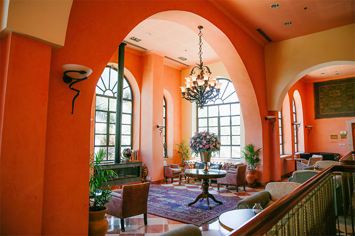 Bright orange room with elegant furniture and chandelier, showcasing a happy color that can transform your home.