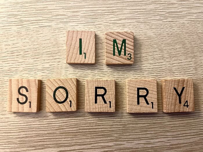 Wooden letters spelling "I'm sorry" on a table, related to hard riddles and testing wits.