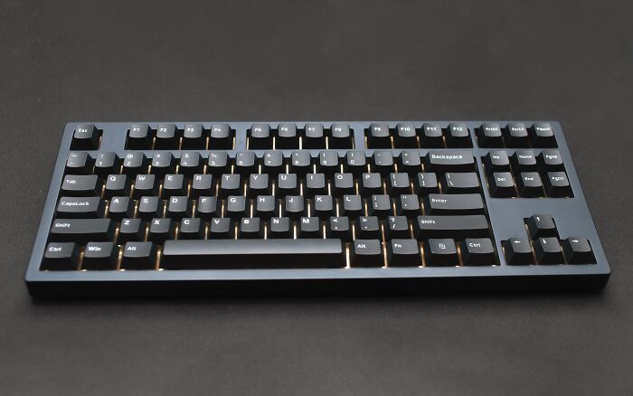 Black computer keyboard on dark table, related to solving hard riddles with keen wits.