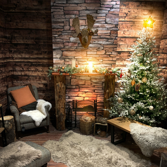 Grey chair and Christmas tree near the fireplace