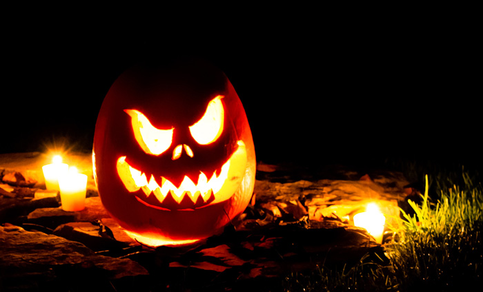 jack-o-lanterns on the ground surrounded by candels 