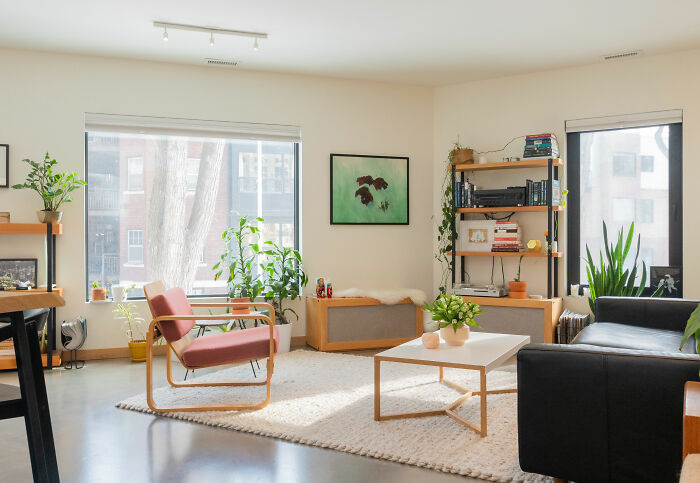 Bright white living room featuring expert-approved interior design ideas with brown furniture and a black couch.