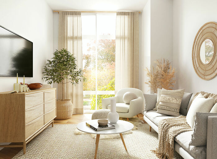 Bright white living room showcasing expert-approved interior design ideas with a white couch, brown rug, and wooden cupboard with TV.