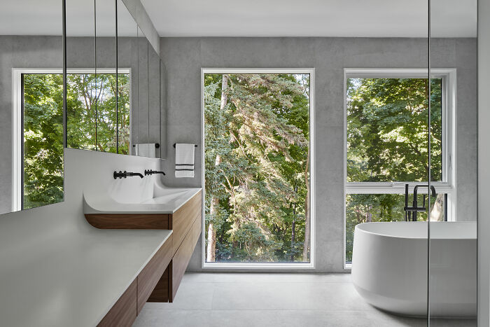 Minimalist white bathroom with modern sink and large windows, showcasing expert-approved interior design ideas for home designs.