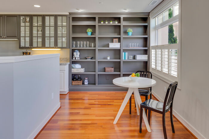 Room featuring a round white wooden table, brown chair, and gray shelves showcasing top home design ideas.