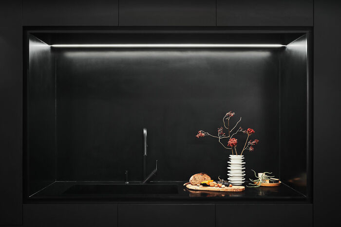 Black kitchen interior with minimal decorations, featuring modern design elements and elegant expert-approved home designs.