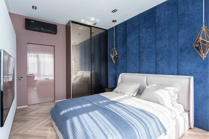 Modern bedroom with blue decor and bed linens showcasing expert-approved interior design ideas for home designs.