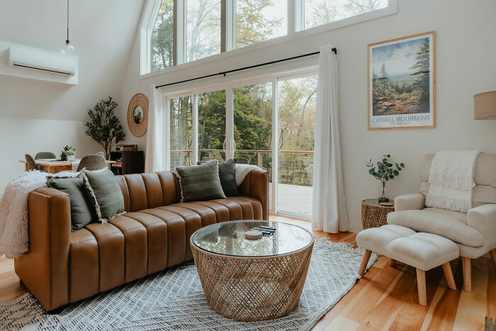 Living room with leather sofa, large window, cozy furniture, and stylish decor showcasing expert-approved interior design ideas.