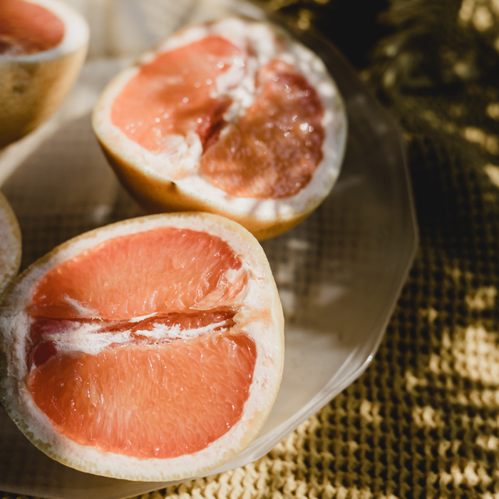 Grapefruit halves on a plate, illustrating natural solutions to keep dogs off the lawn.