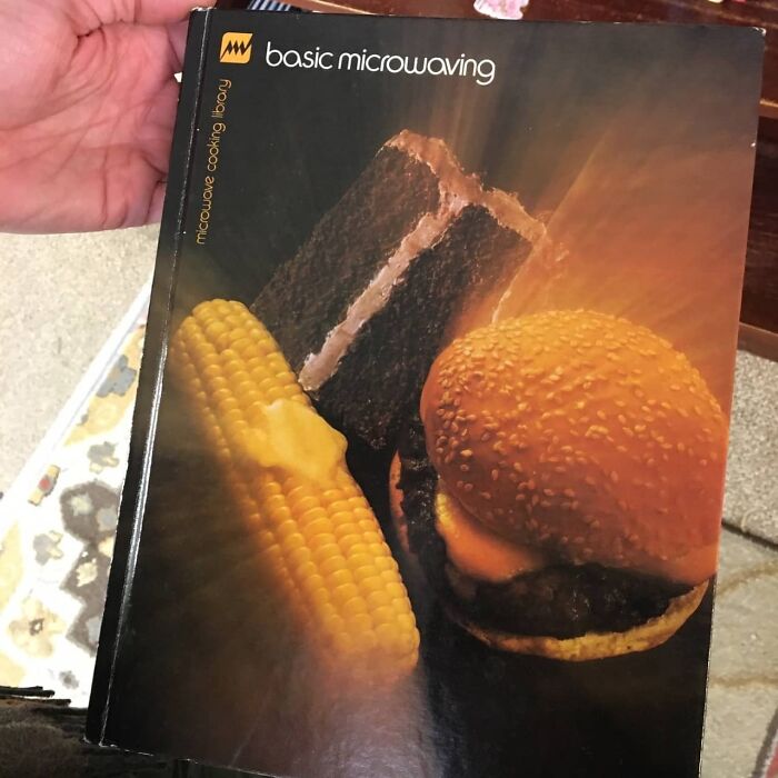 Vintage basic microwaving cookbook with images of corn, sandwich, and chocolate cake, one of the weird items donated to thrift stores.