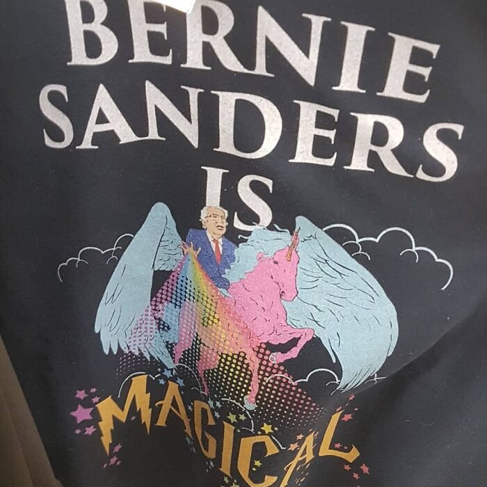 T-shirt featuring a whimsical design of Bernie Sanders riding a colorful winged unicorn, a weird thrift store donation item.