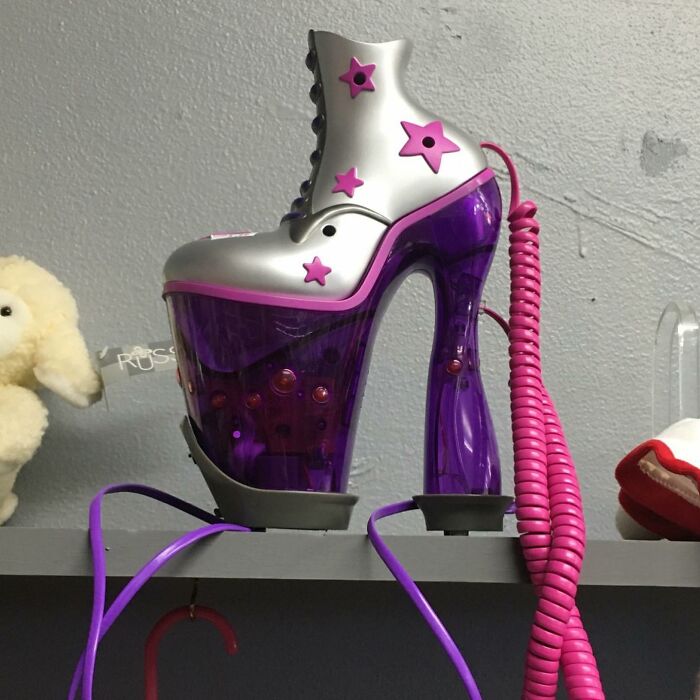 Purple and silver high-heeled shoe phone with star decorations, one of the weird items donated to thrift stores.