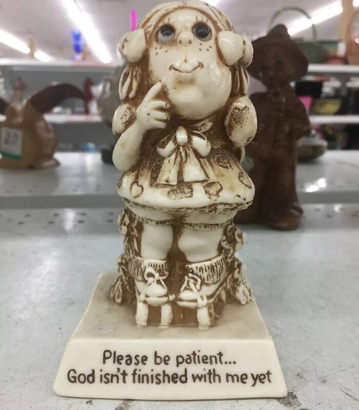 Ceramic figurine with a whimsical face and inscription, one of the weird items donated to thrift stores.