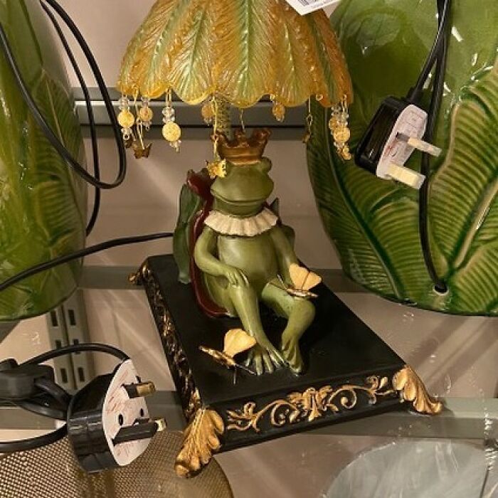 Green frog figurine lamp with crown and butterflies, a weird thrift store donation featured on an IG page.