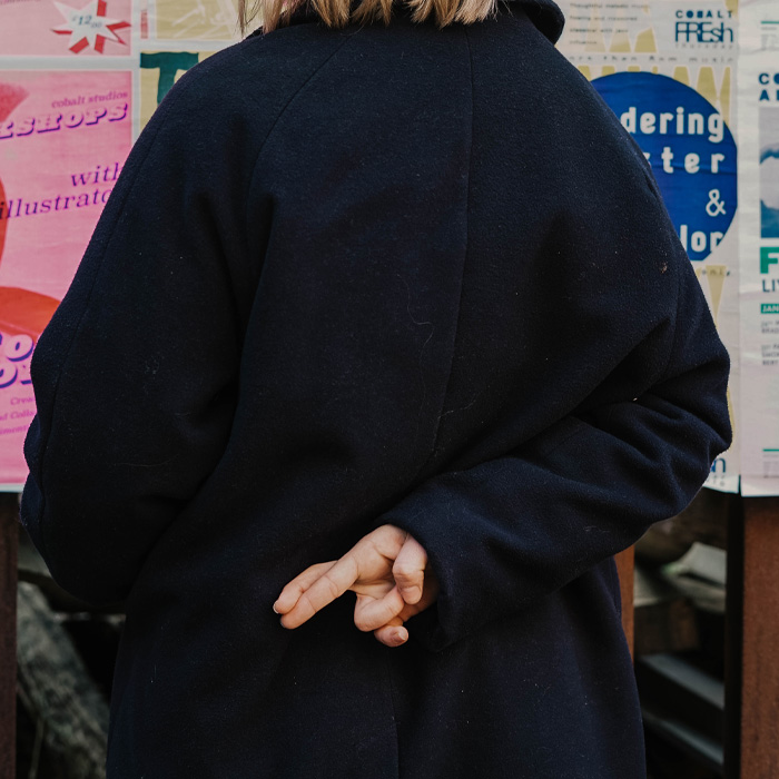 Woman with fingers crossed behind her back