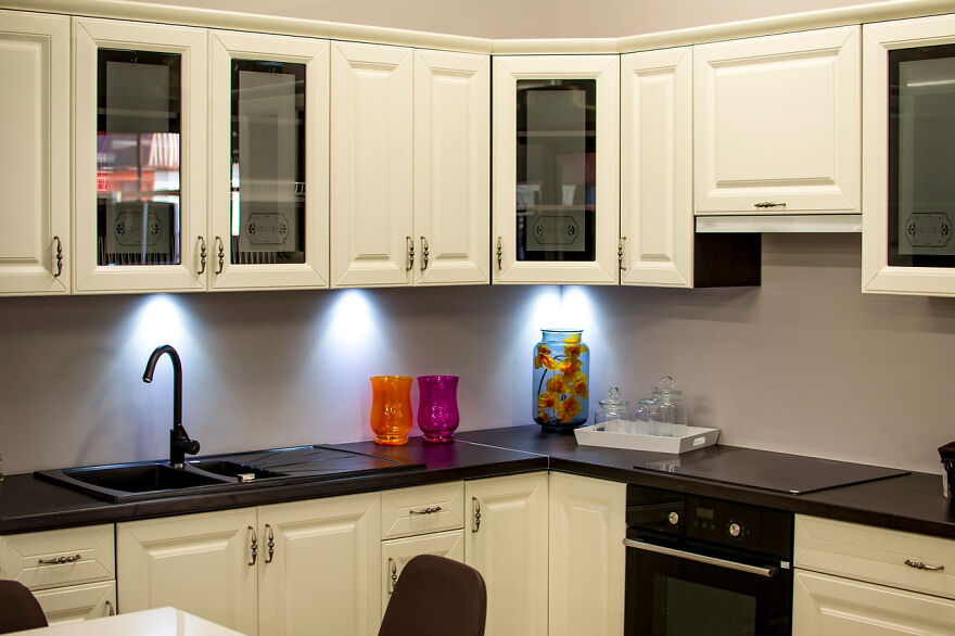 Colorful vases on countertops in a black and white kitchen featuring modern and stylish kitchen cabinets.