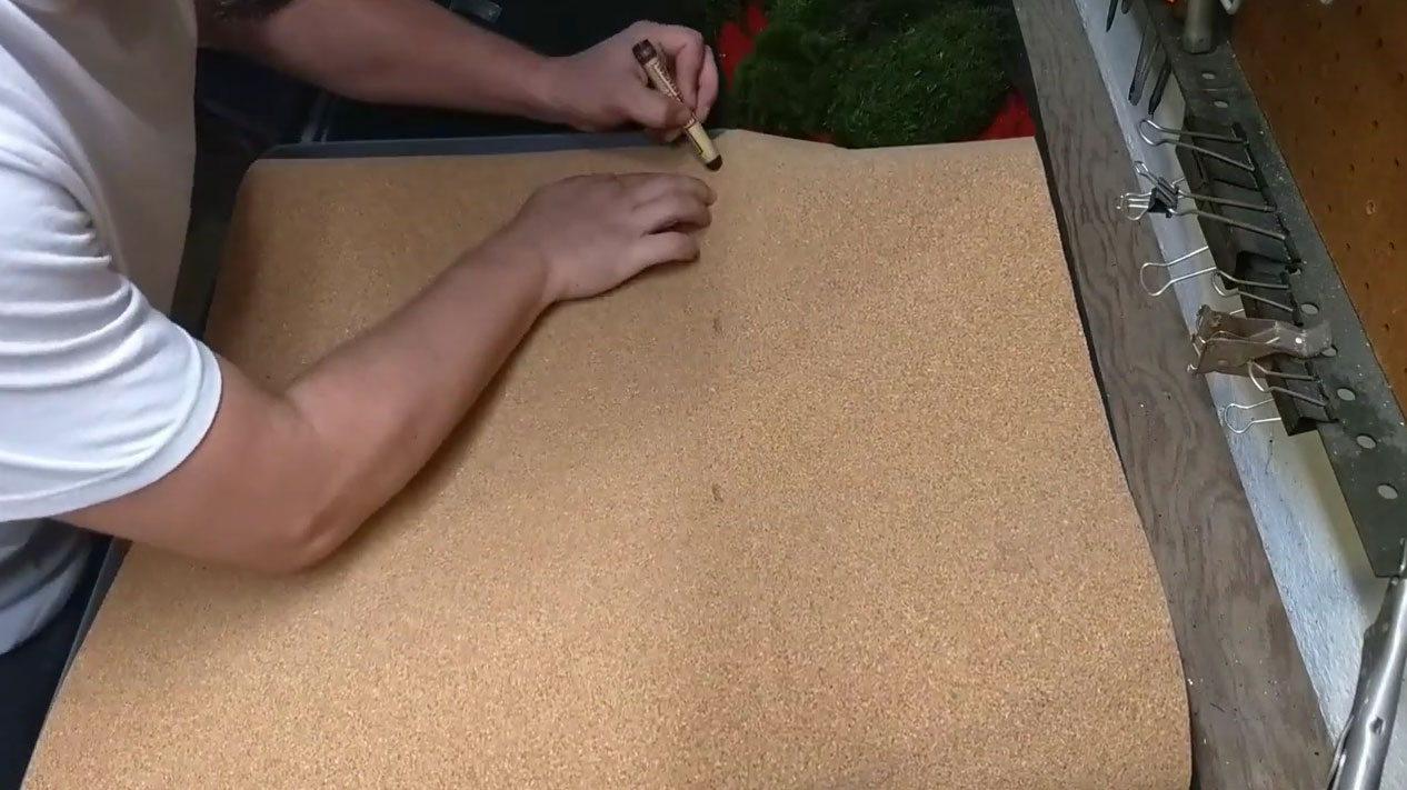 Person measuring and marking non-slip shelf liner for DIY moss rugs and bath mats project on wooden table. Person measuring and marking non-slip shelf liner for DIY moss rugs and bath mats project on wooden table.