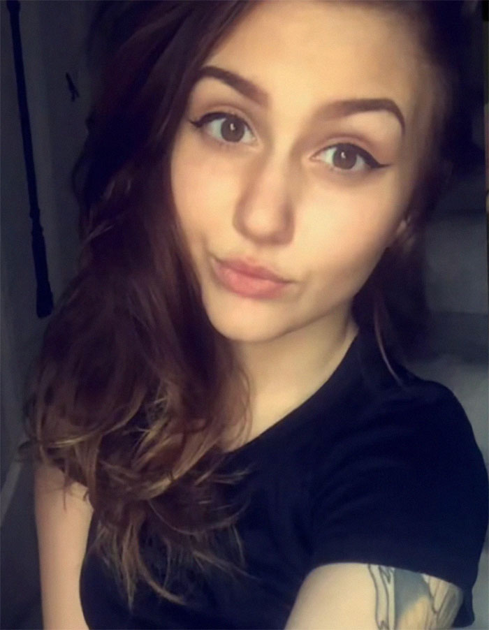 Woman with tattoos poses for a selfie, showcasing her inked look after years of body modifications.