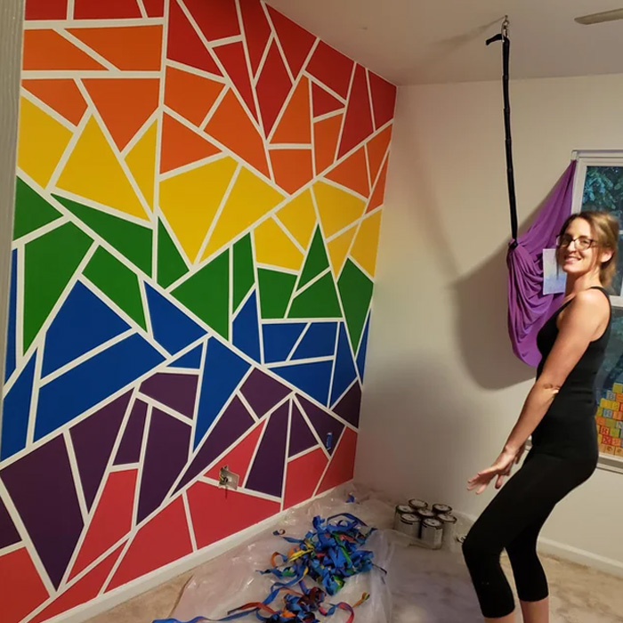 Woman smiling in front of a coloured wall