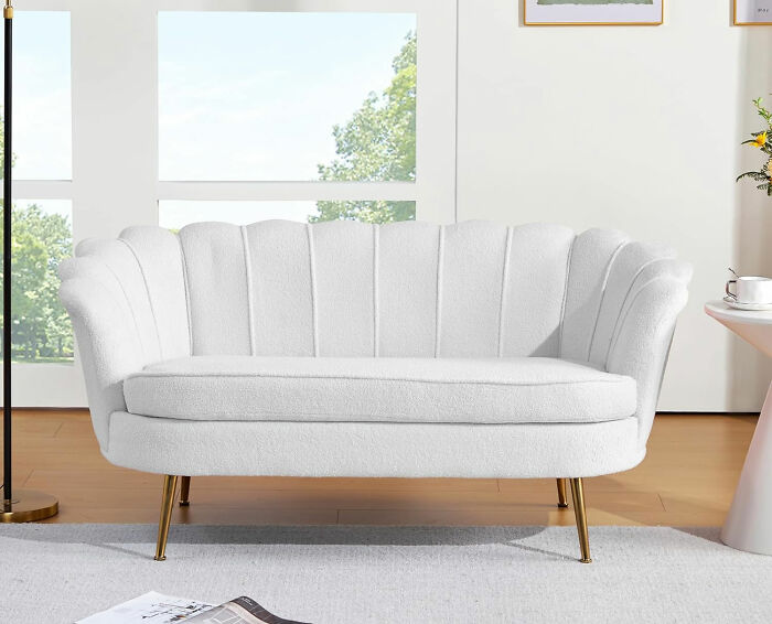 Small white teddy velvet couch with gold legs in a modern living room, designed to maximize space in style.