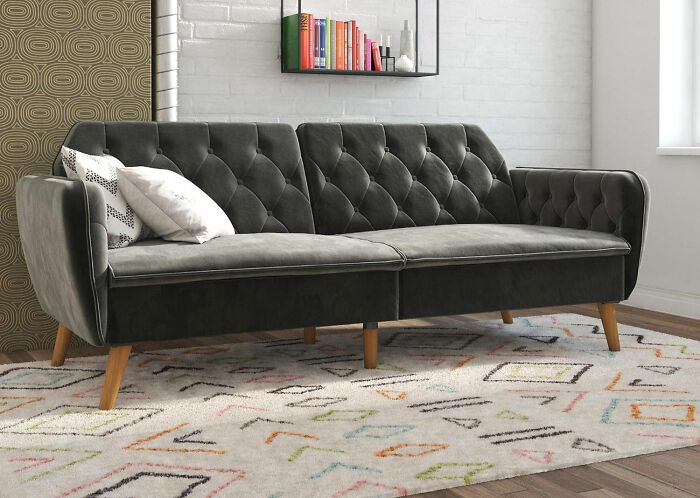 Novogratz small futon couch with tufted design and wooden legs, perfect for maximizing space with style.