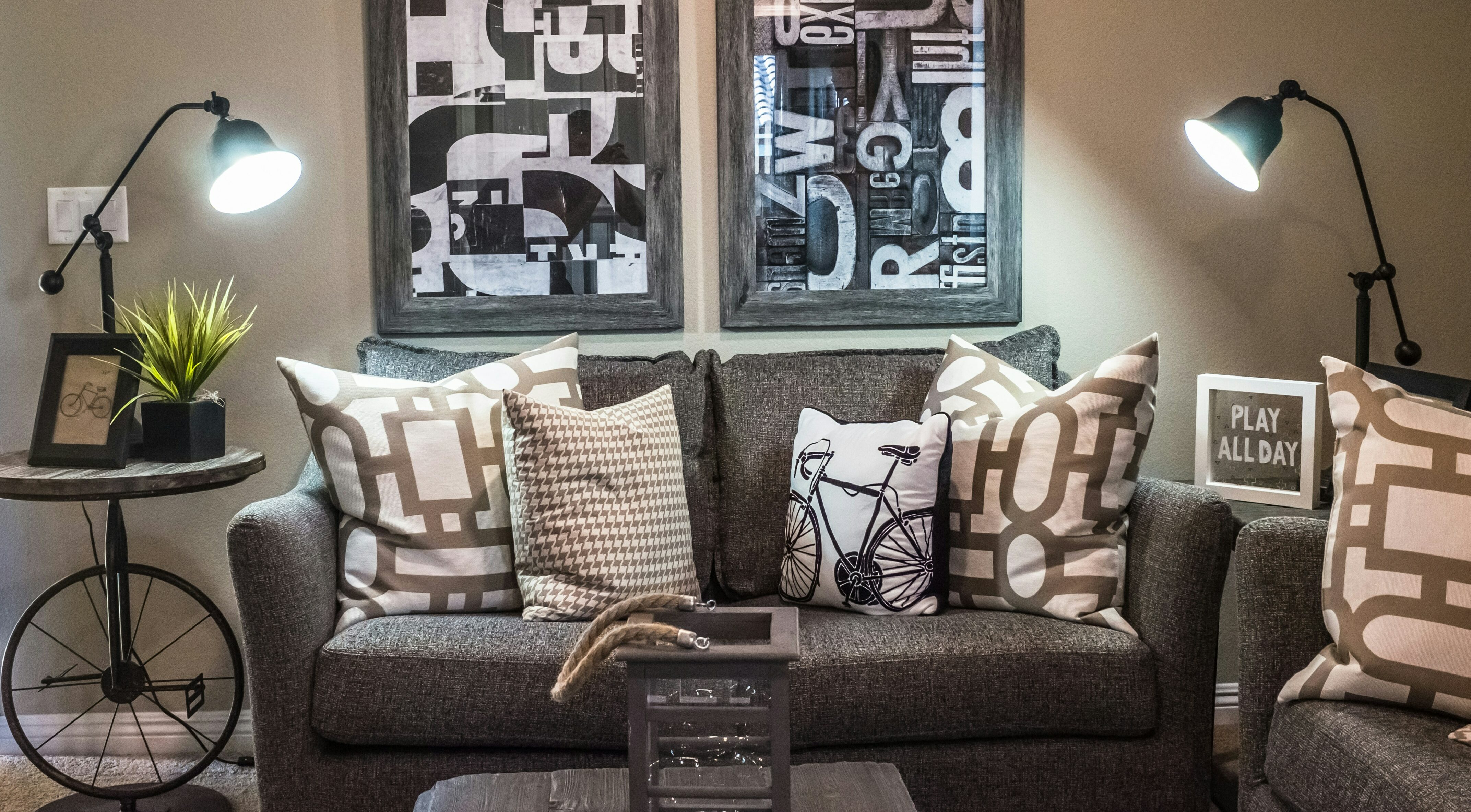 small dark gray couch with pillows and lamps on tables