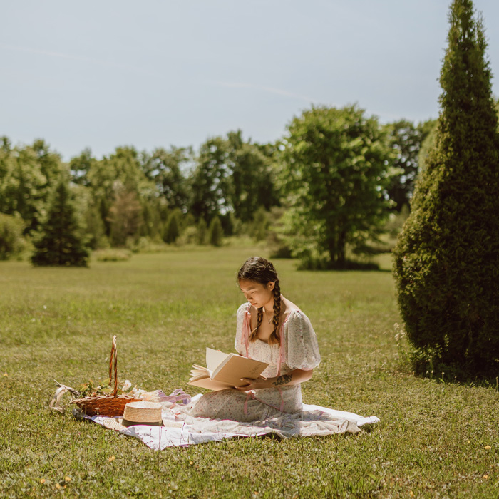 A woman wearing dress reading a book 