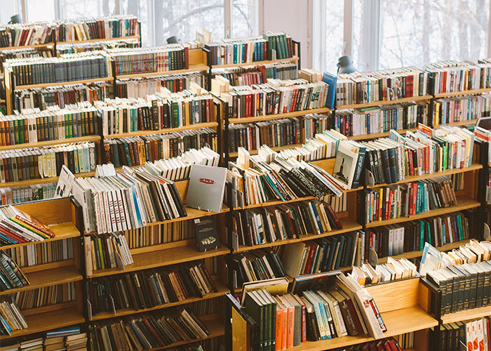 Library interior with shelves filled with books, illustrating lesser-known frugal tips having the biggest impact.