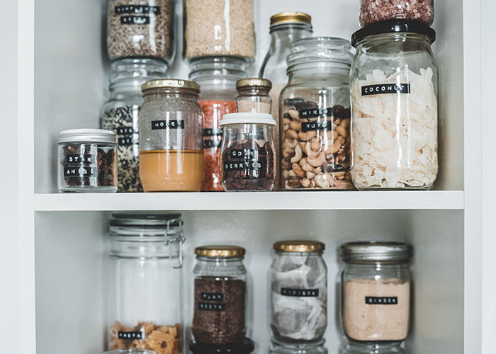 Organized pantry jars with labeled ingredients showcasing lesser-known frugal tips for impactful home storage and savings.