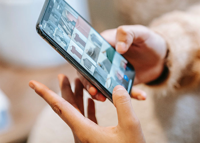 Person browsing a smartphone displaying images, illustrating lesser-known frugal tips shared in an online thread.