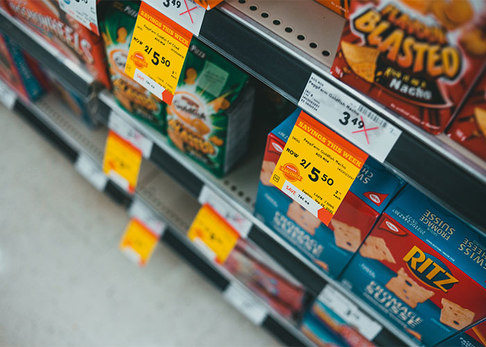 Grocery store shelves with discounted snack prices highlighting lesser-known frugal tips for big savings.