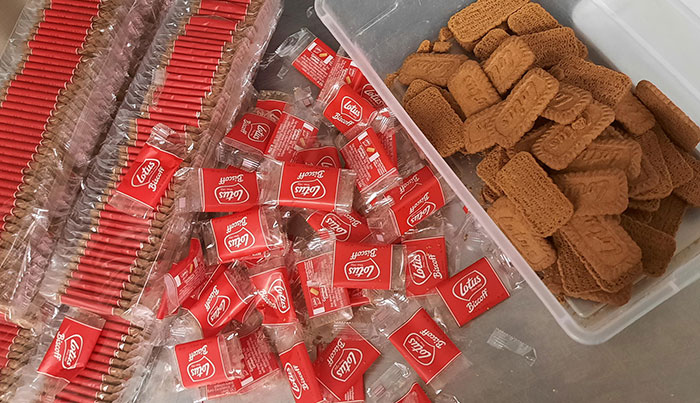 Biscuits spilling from poorly designed packaging with loose wrappers causing a messy and inconvenient snack experience.