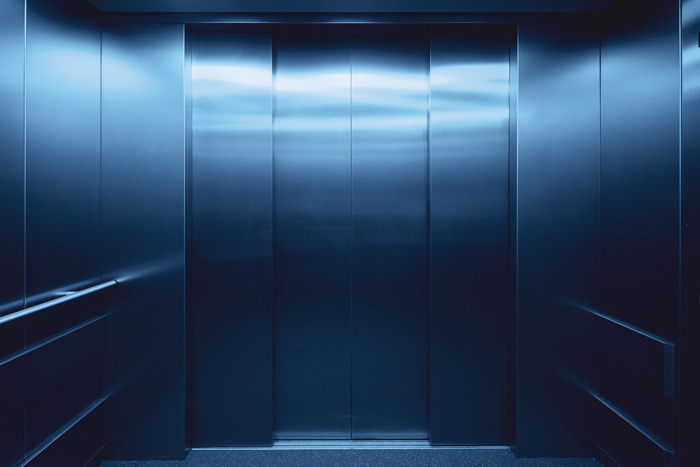 Closed elevator doors with metallic panels in a dimly lit space, related to weird Guinness World records concepts.