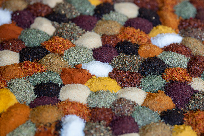 Assorted colorful spices safe for dogs in small mounds.