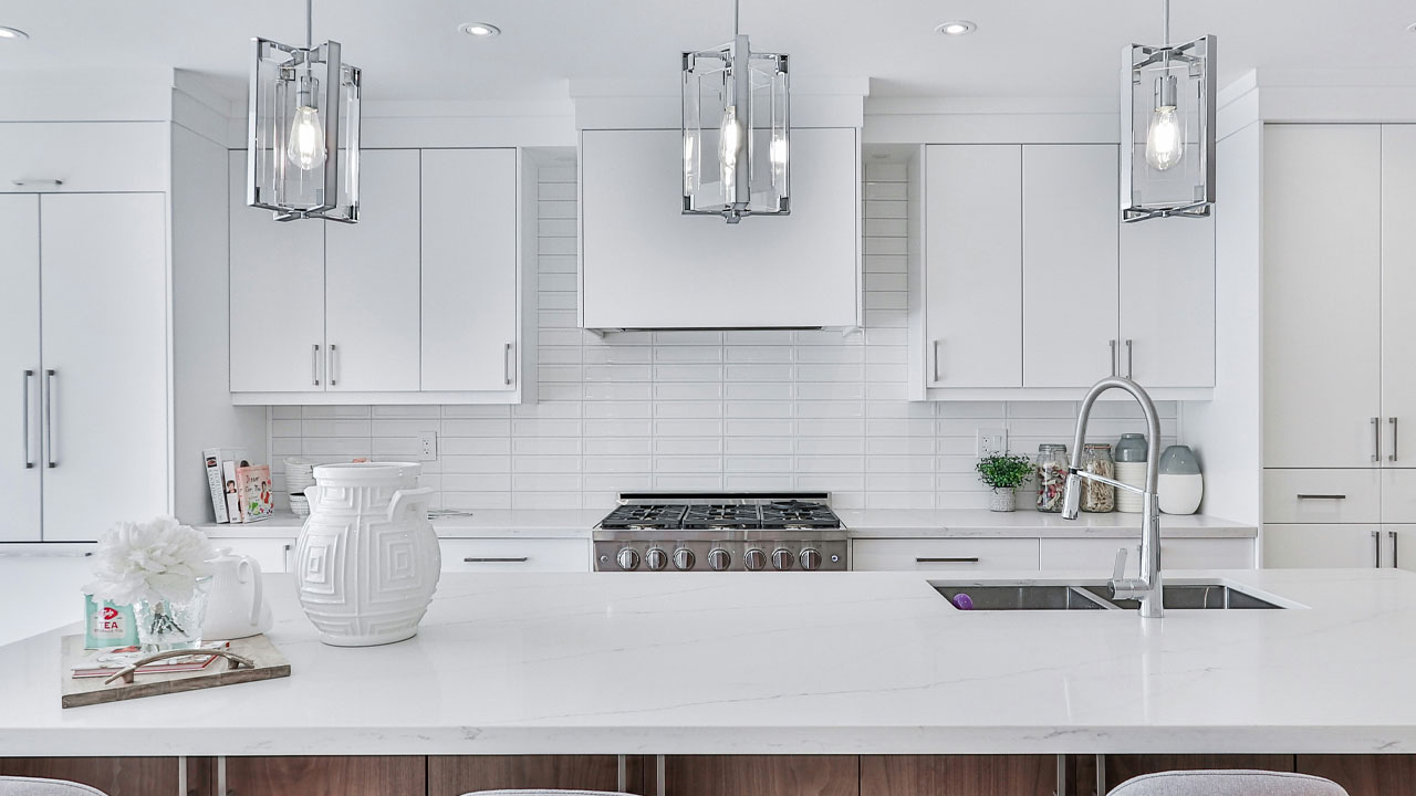 Bright modern kitchen featuring sleek white kitchen cabinets and a spacious marble countertop island with a faucet. Bright modern kitchen featuring sleek white kitchen cabinets and a spacious marble countertop island with a faucet.