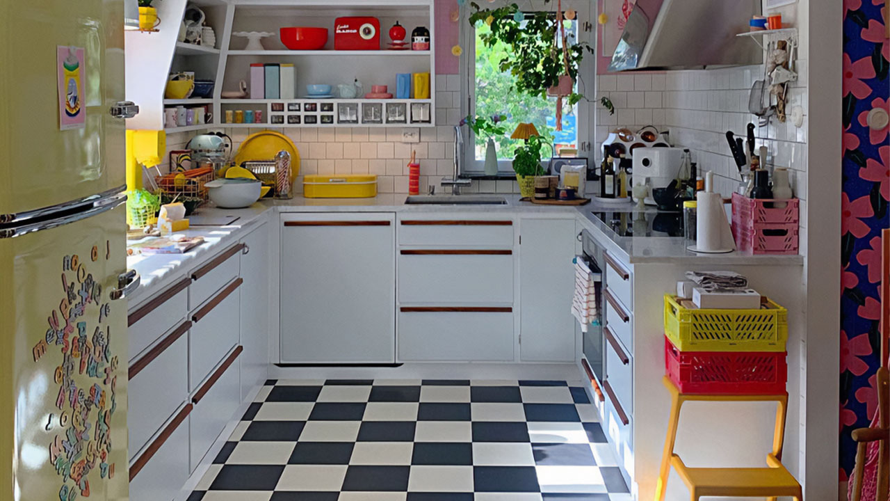 Kitchen with white kitchen cabinets and retro elements featuring a checkered floor and colorful vintage appliances. Kitchen with white kitchen cabinets and retro elements featuring a checkered floor and colorful vintage appliances.