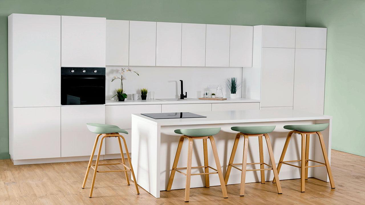 Modern kitchen with white kitchen cabinets, green walls, wooden flooring, and an island with light green stools. Modern kitchen with white kitchen cabinets, green walls, wooden flooring, and an island with light green stools.