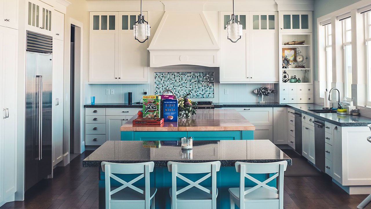 Kitchen with white kitchen cabinets and blue island featuring modern lighting and large windows for natural light. Kitchen with white kitchen cabinets and blue island featuring modern lighting and large windows for natural light.
