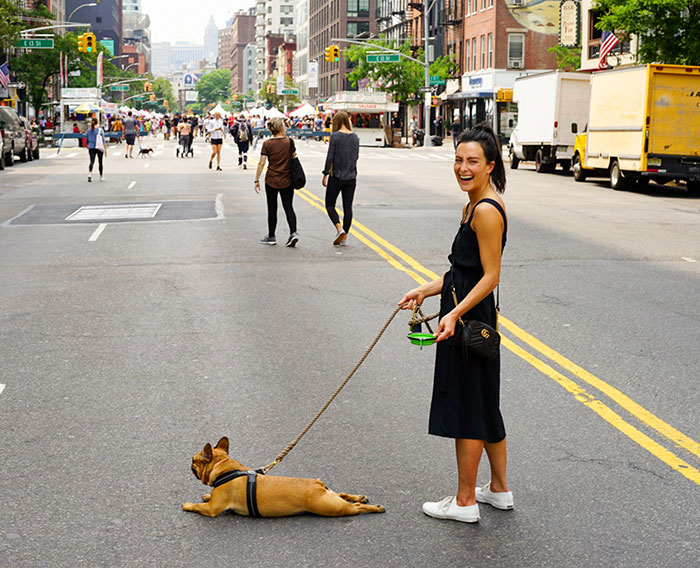Woman with dog splooting on a busy street in the city. Woman with dog splooting on a busy street in the city.